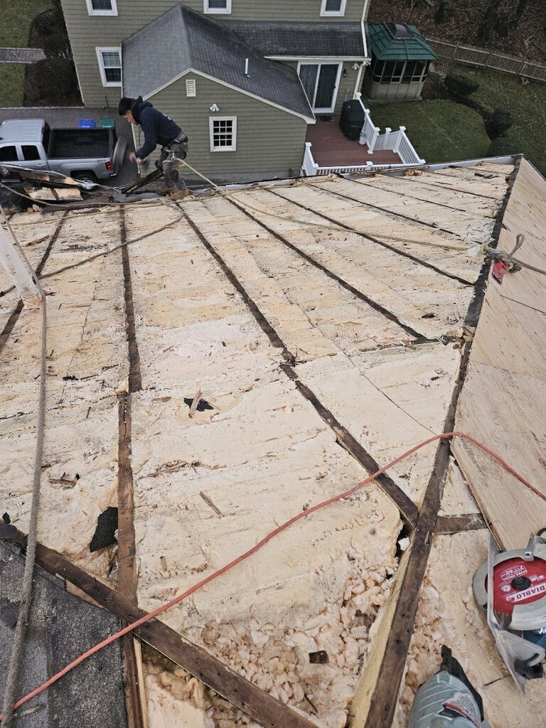 A man is working on the roof of a house.
