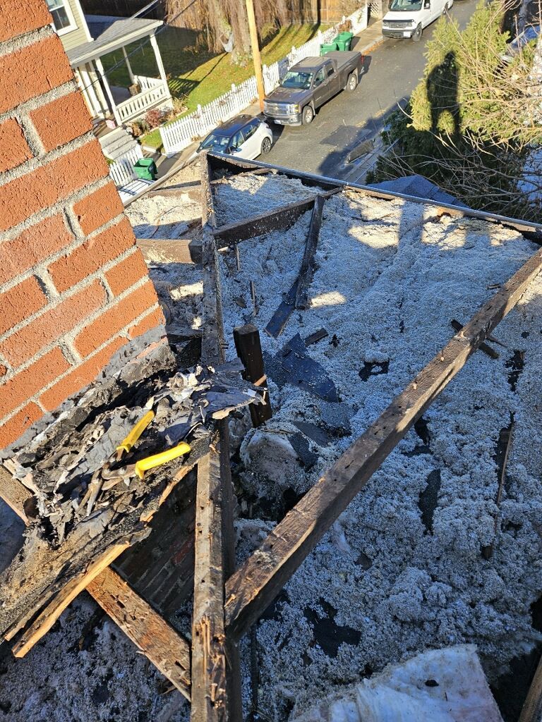 A brick building with a roof that has been damaged by a fire.