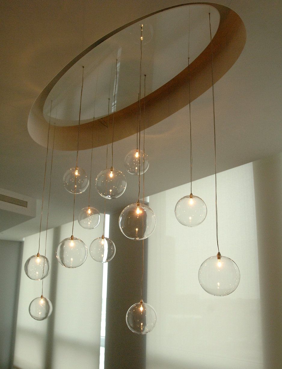 Modern chandelier with clear glass globes hanging from a wooden circular frame.