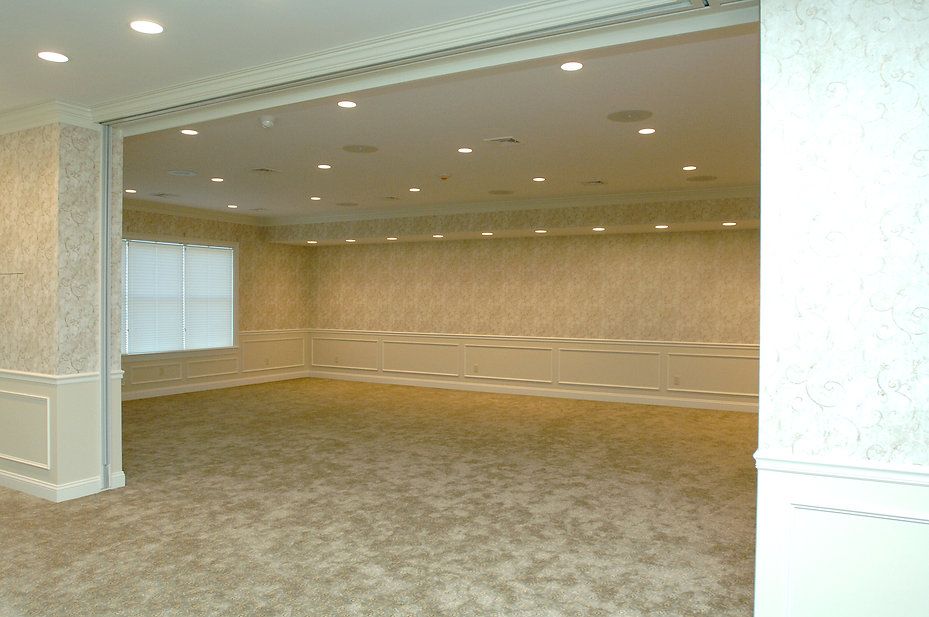 Empty, carpeted room with tan patterned walls and recessed lighting. Beige trim.