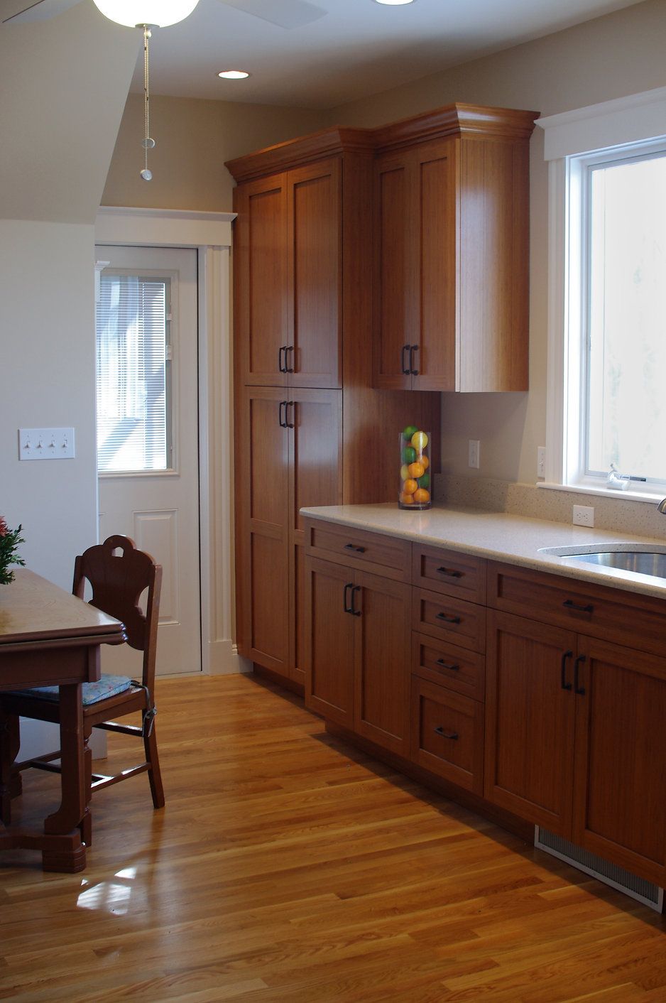 Kitchen with light brown cabinets, a wooden floor, and a table with a chair.