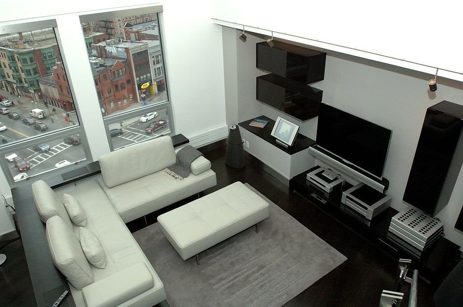 Modern living room with a sectional sofa, city view, and entertainment system.