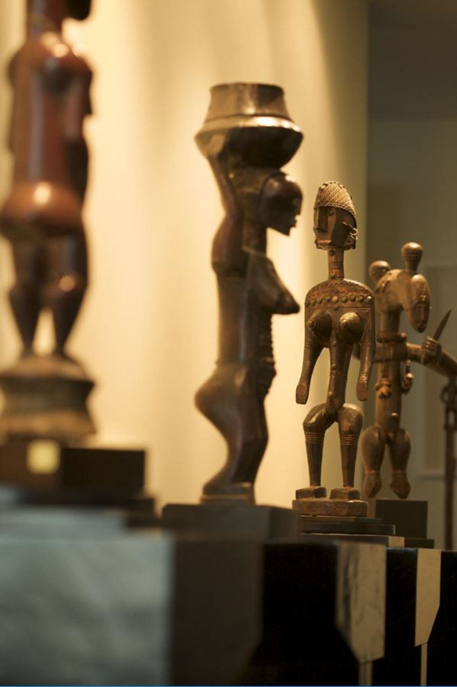 Bronze statues on display: figures of women and people with stylized features.