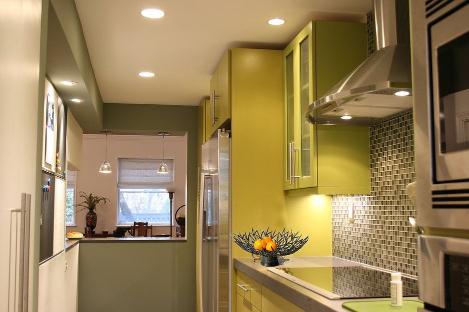 Modern kitchen with lime green cabinets and backsplash, stainless steel appliances.