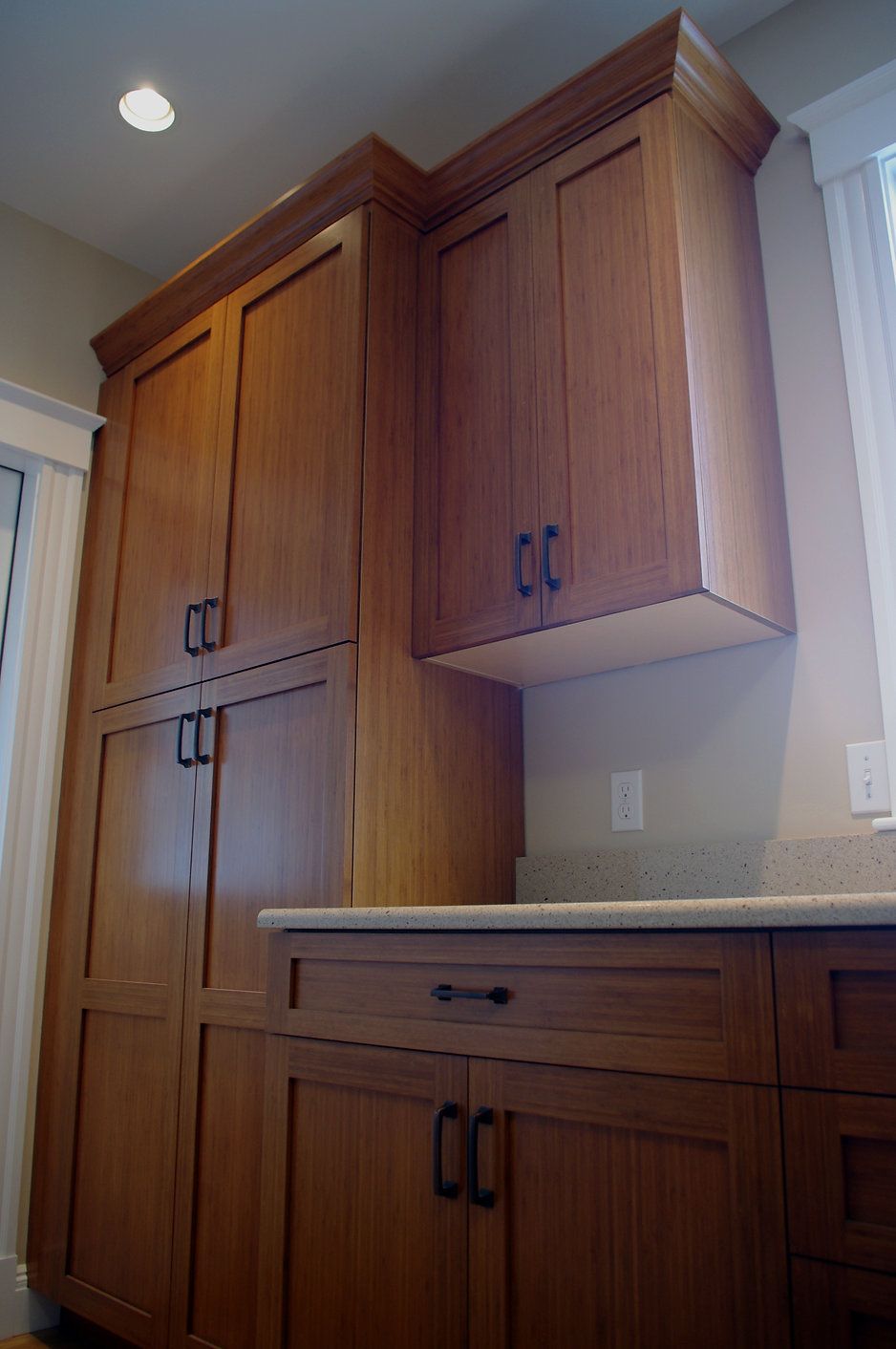 Wooden kitchen cabinets with black handles.