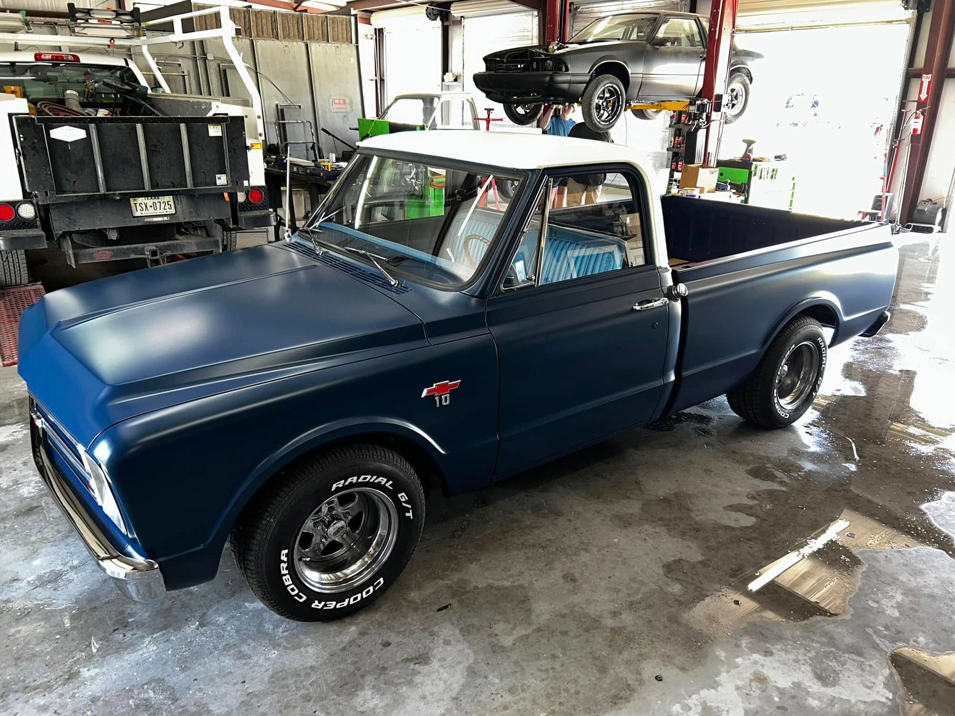 Blue classic Chevy pickup truck in a garage.