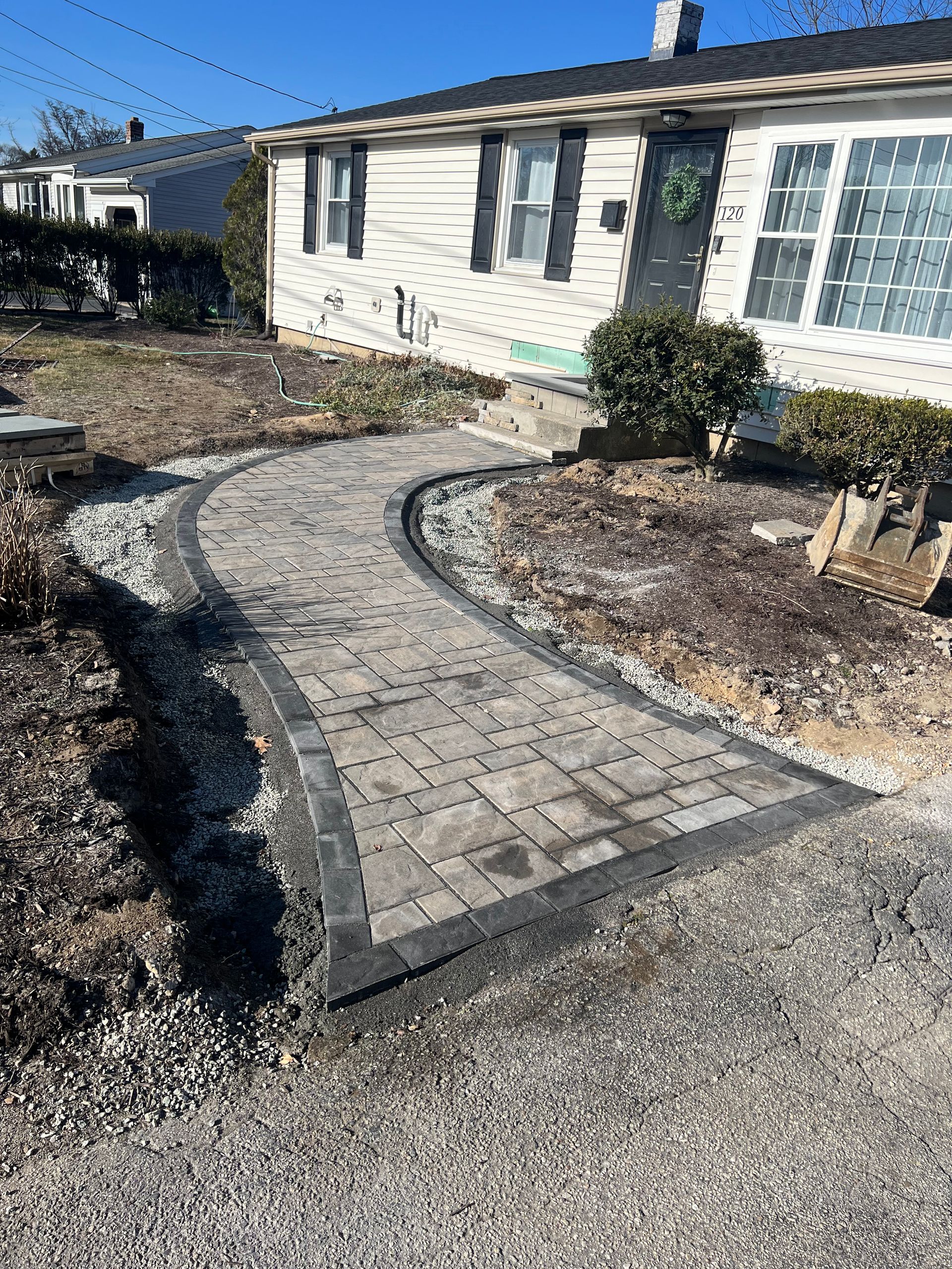 A brick walkway is being built in front of a house.