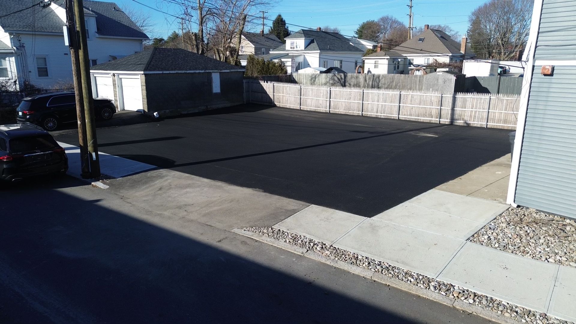 A car is parked in a parking lot next to a house.