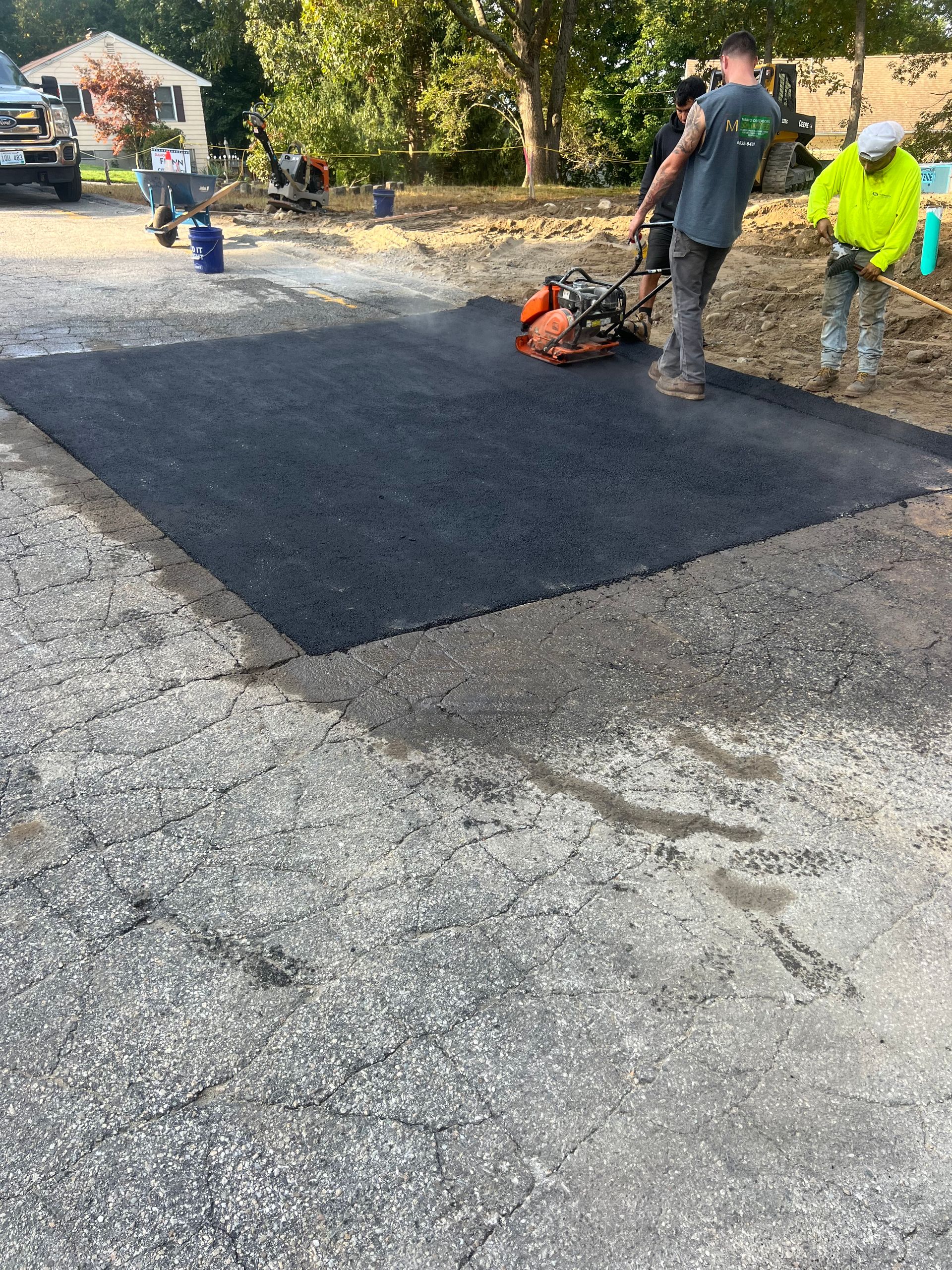 A group of men are working on a driveway.