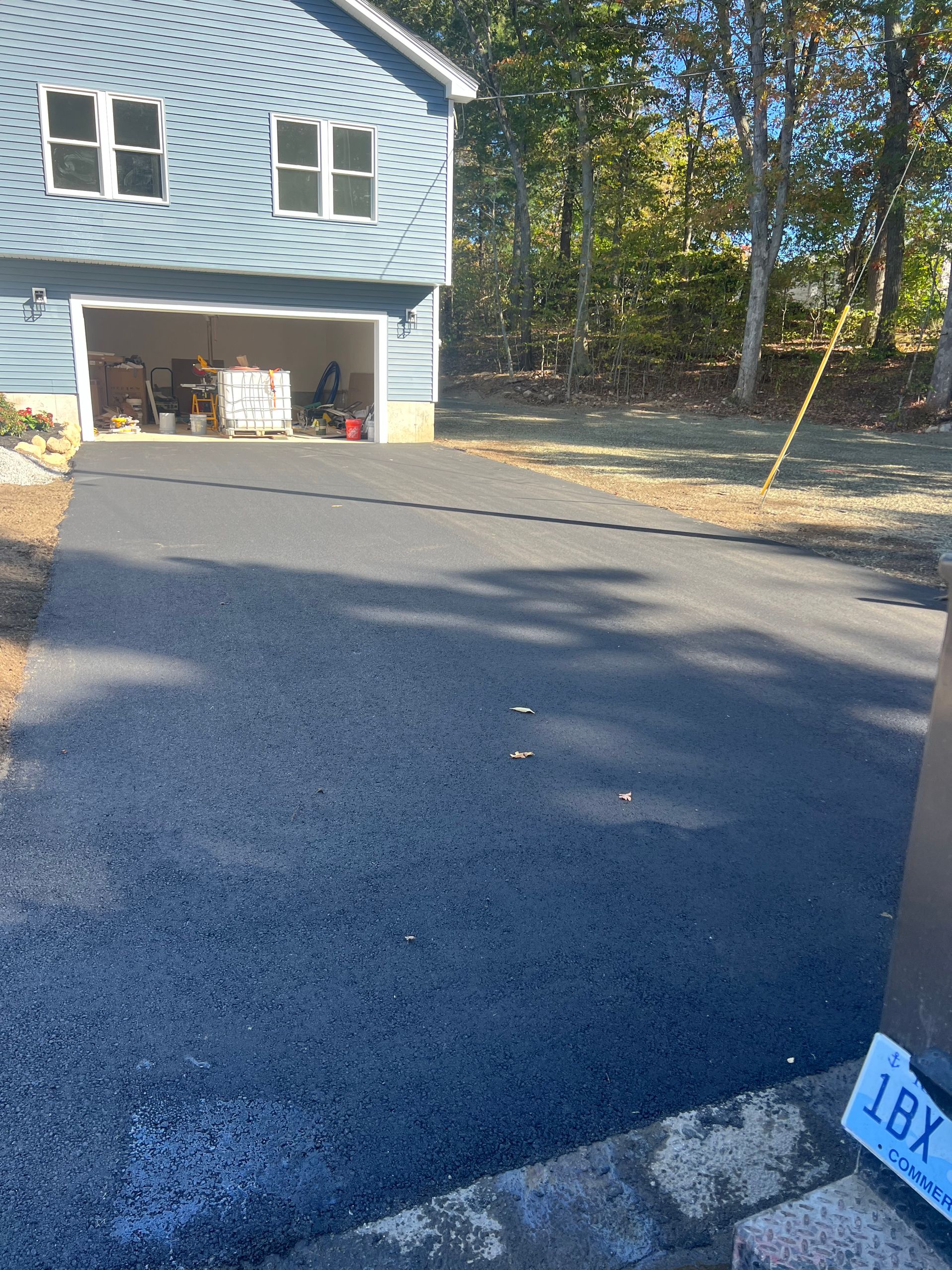 A driveway leading to a house with a license plate that says lby