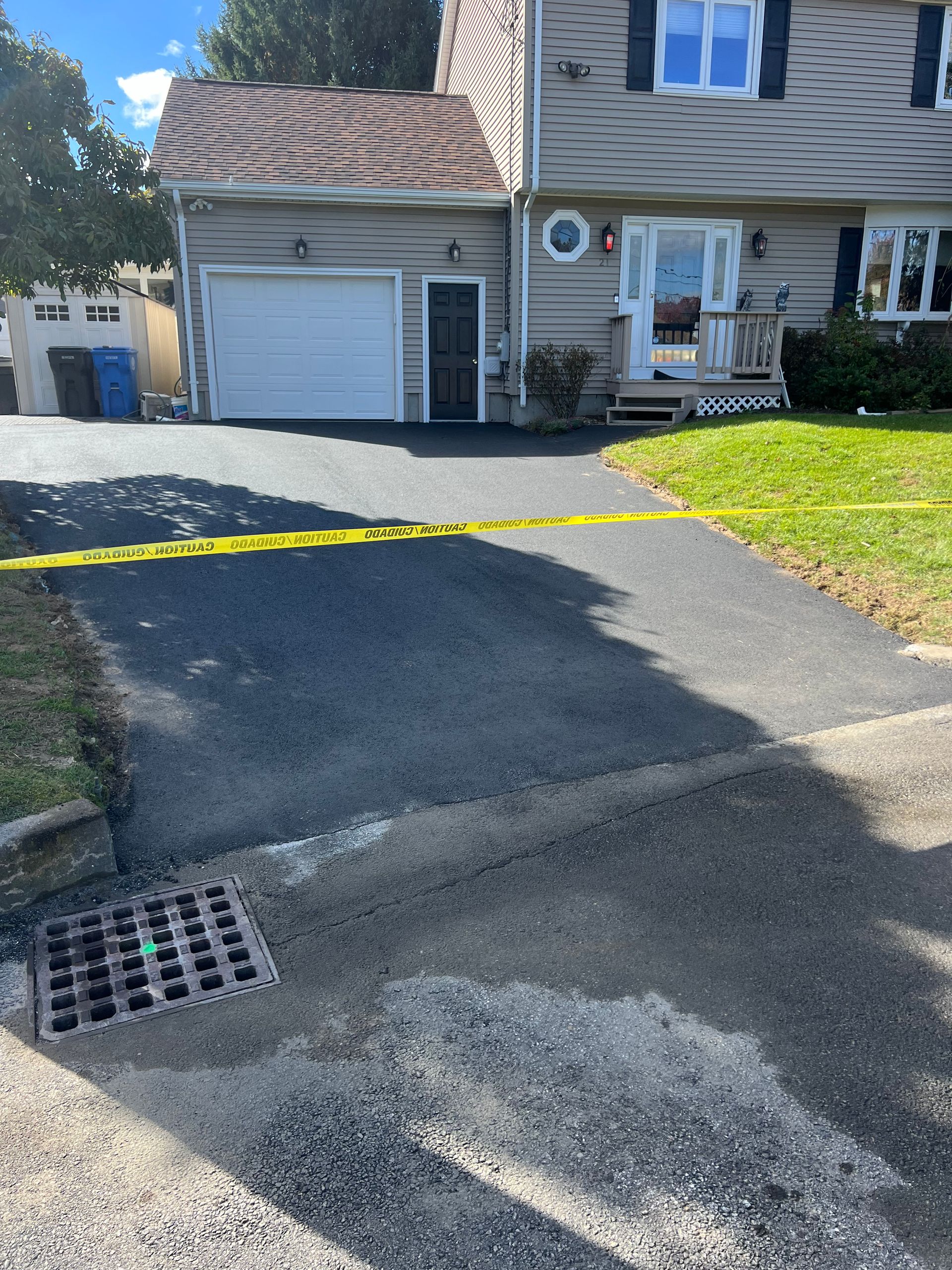 A driveway leading to a house with a yellow tape around it