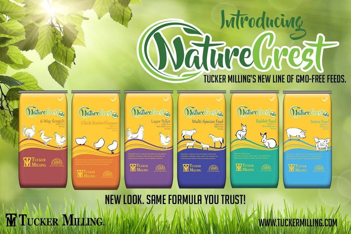 Advertisement for Nature Crest, Tucker Milling's new line of GMO-free feeds, with colorful feed cans and a green background.