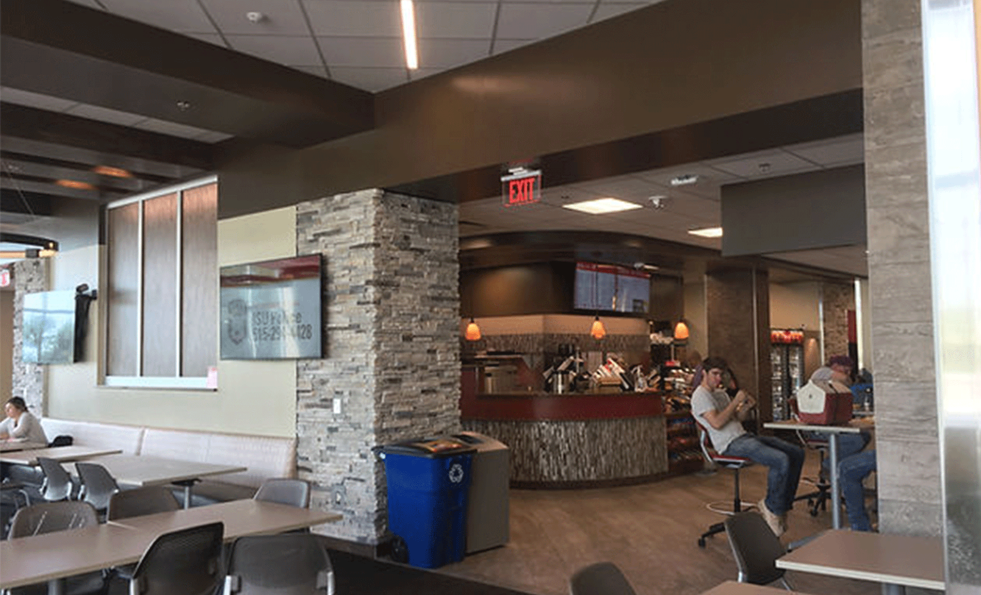 a group of people are sitting at tables in a restaurant .