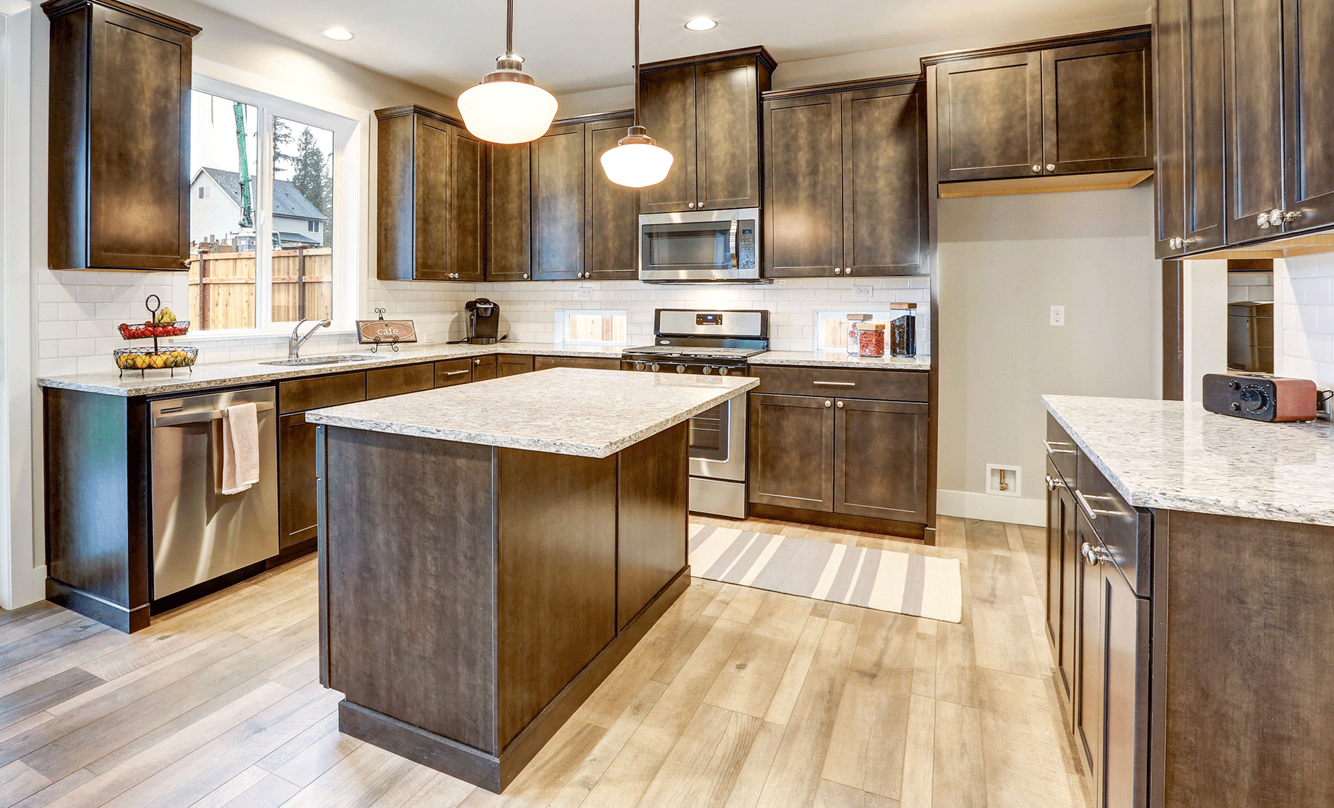 Kitchen with dark wood cabinets, light countertops, island, and wood floor.