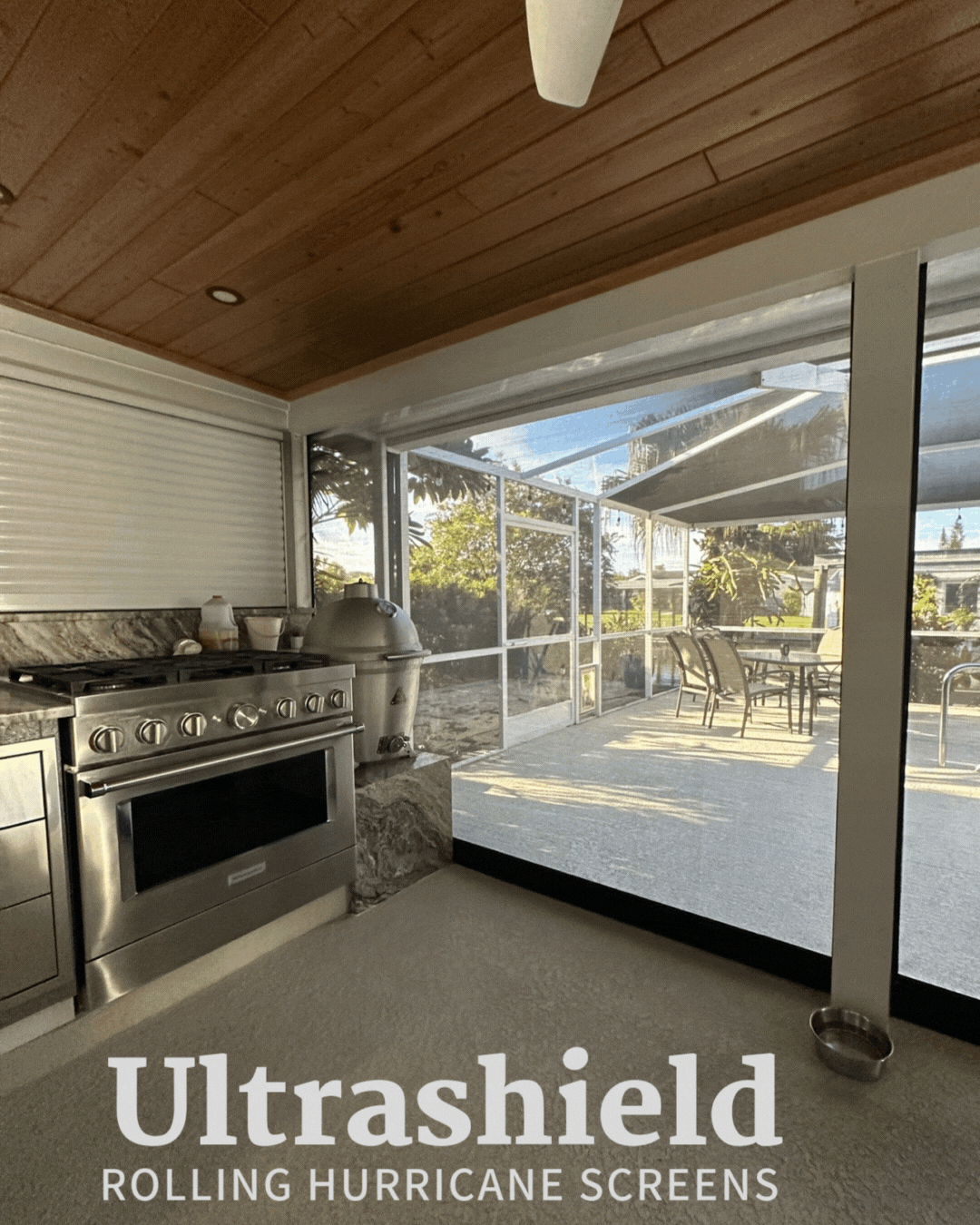 Covered patio with stainless grill, sliding glass doors, and outdoor dining area under a wood ceiling.