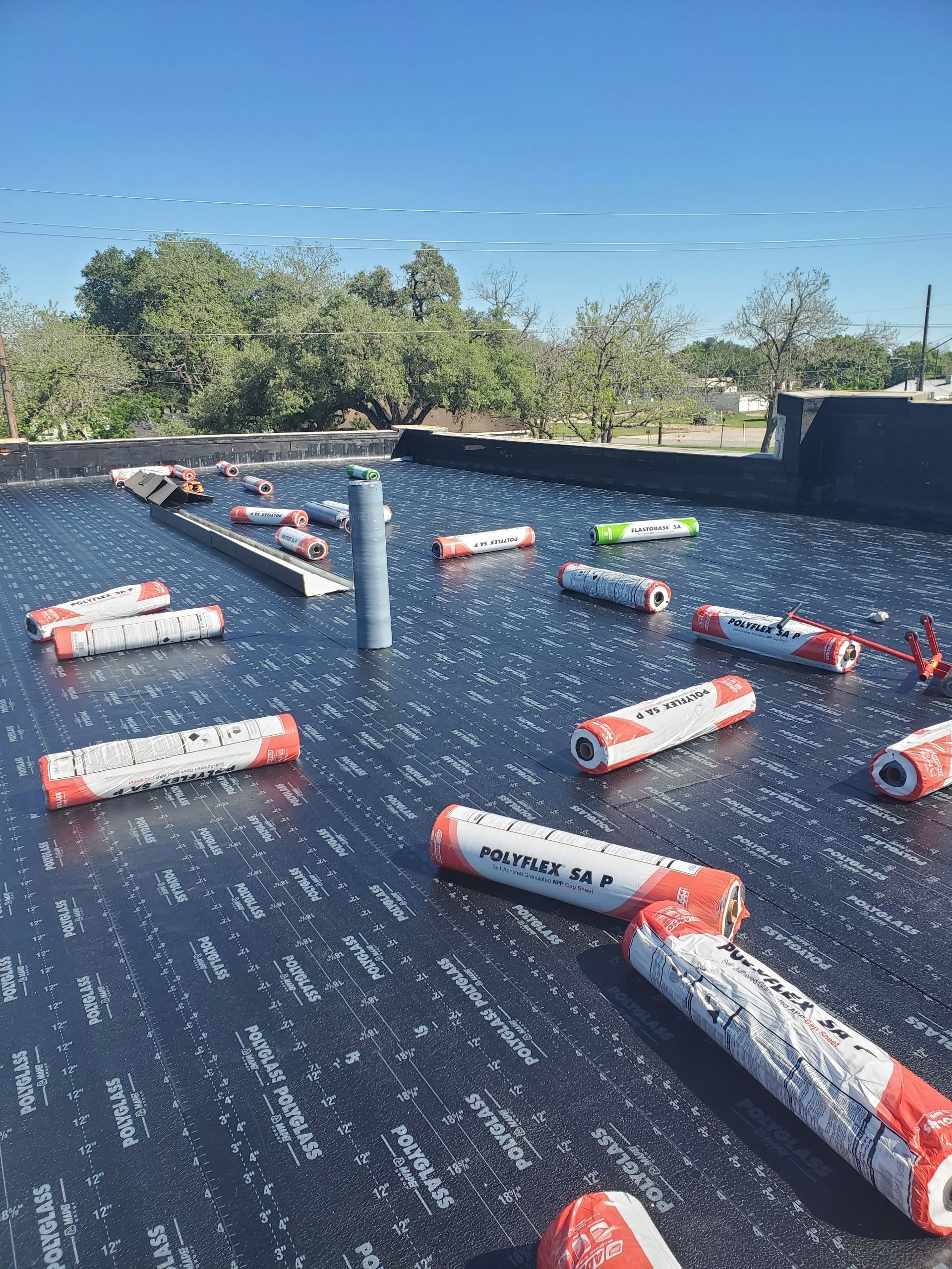 A roof with a lot of rolls of roofing material on it - during