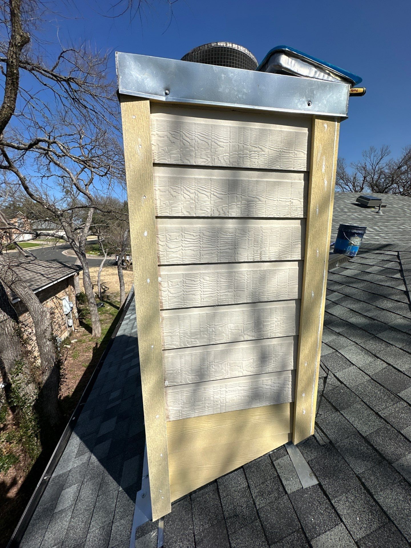 A chimney is sitting on top of a roof - before