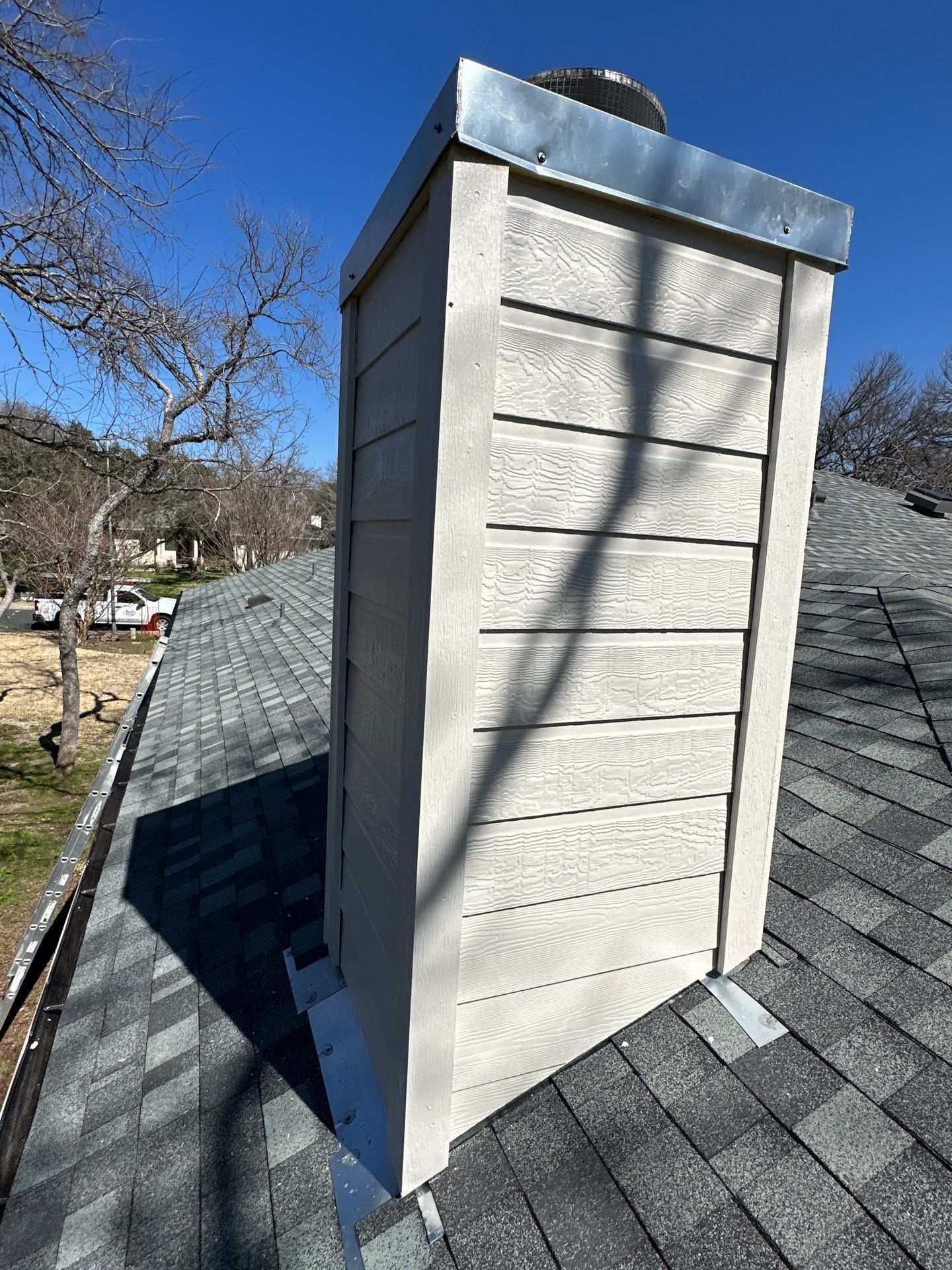 A chimney is sitting on top of a roof - after