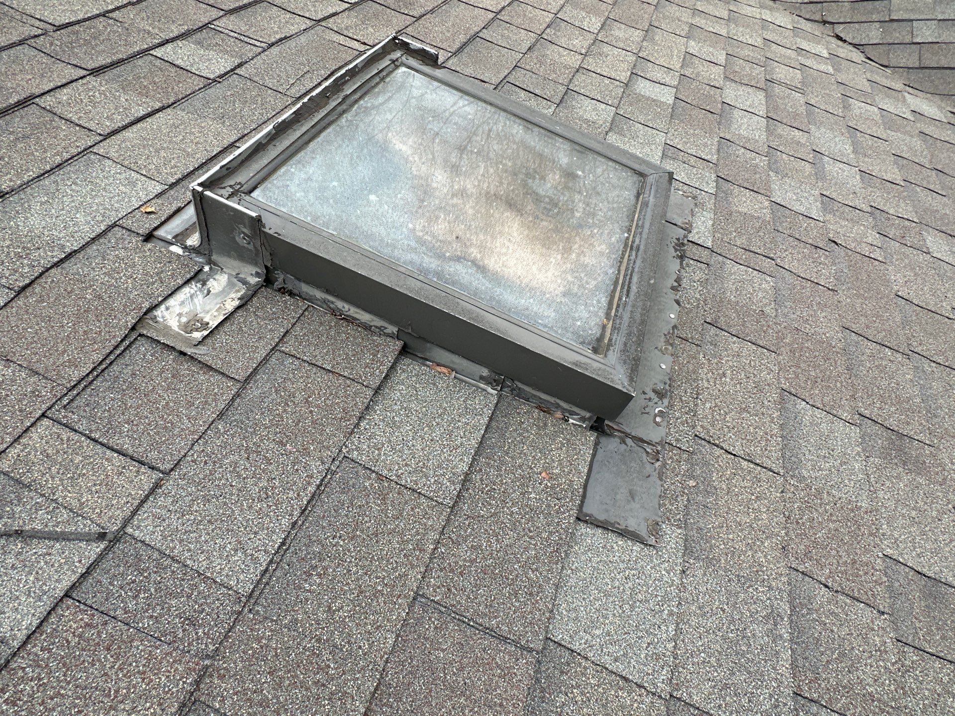 A square skylight is sitting on top of a roof - after