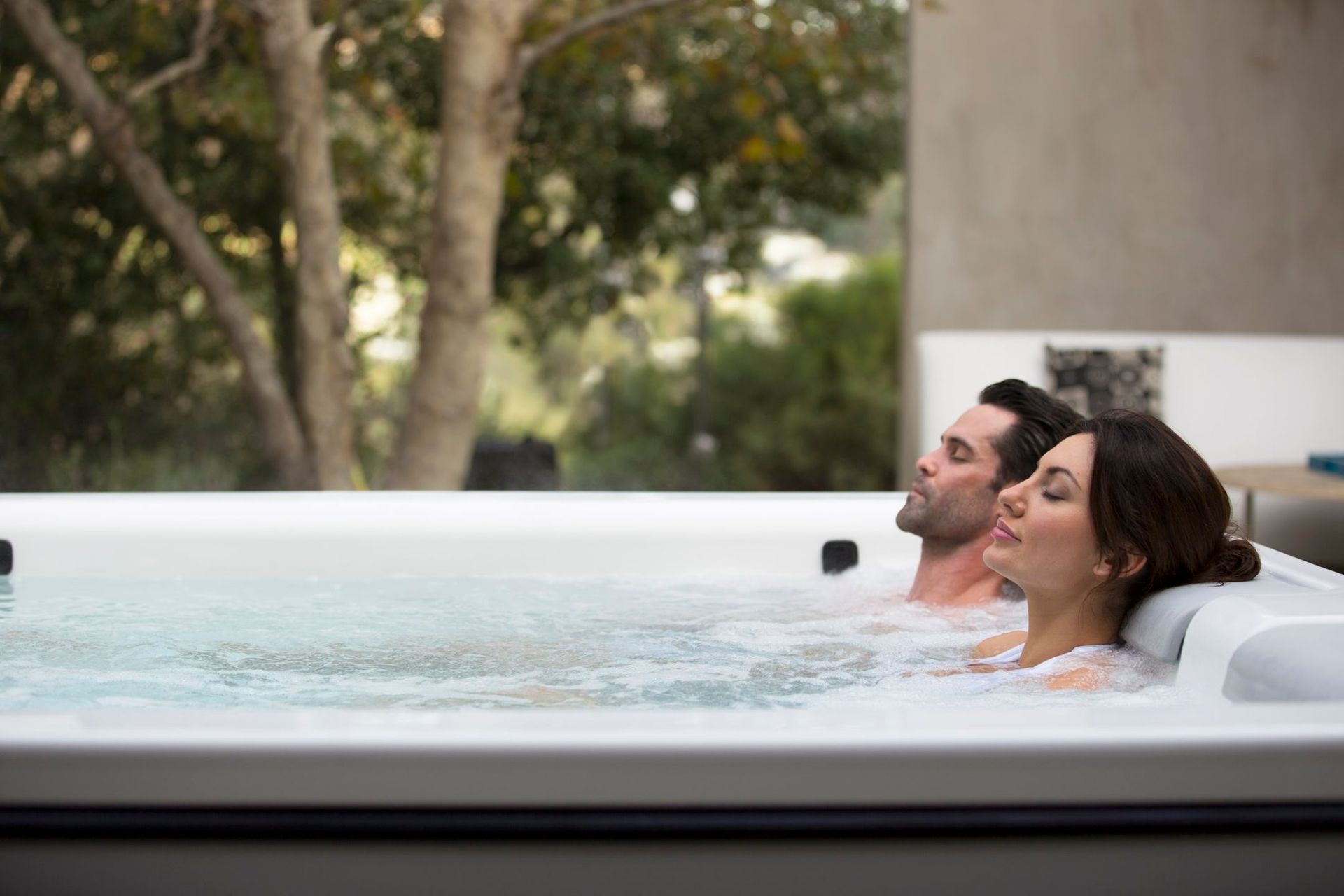A man and a woman are sitting in a hot tub.