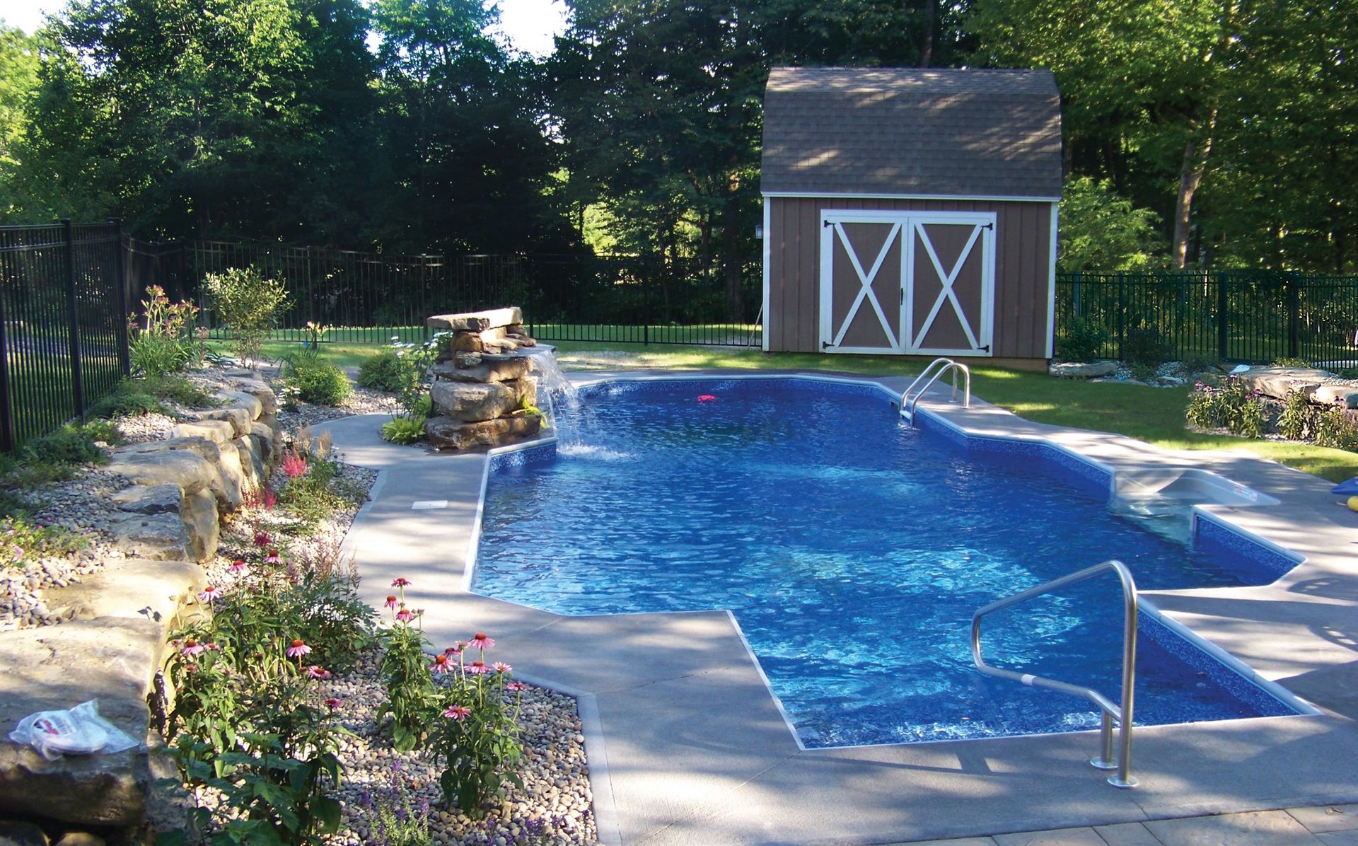 A large swimming pool with a barn in the background