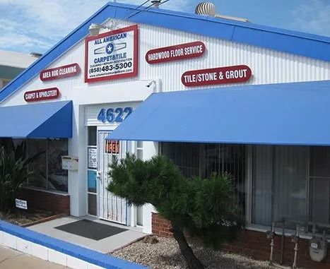 Commercial storefront with blue awnings and red signage on a sunny day