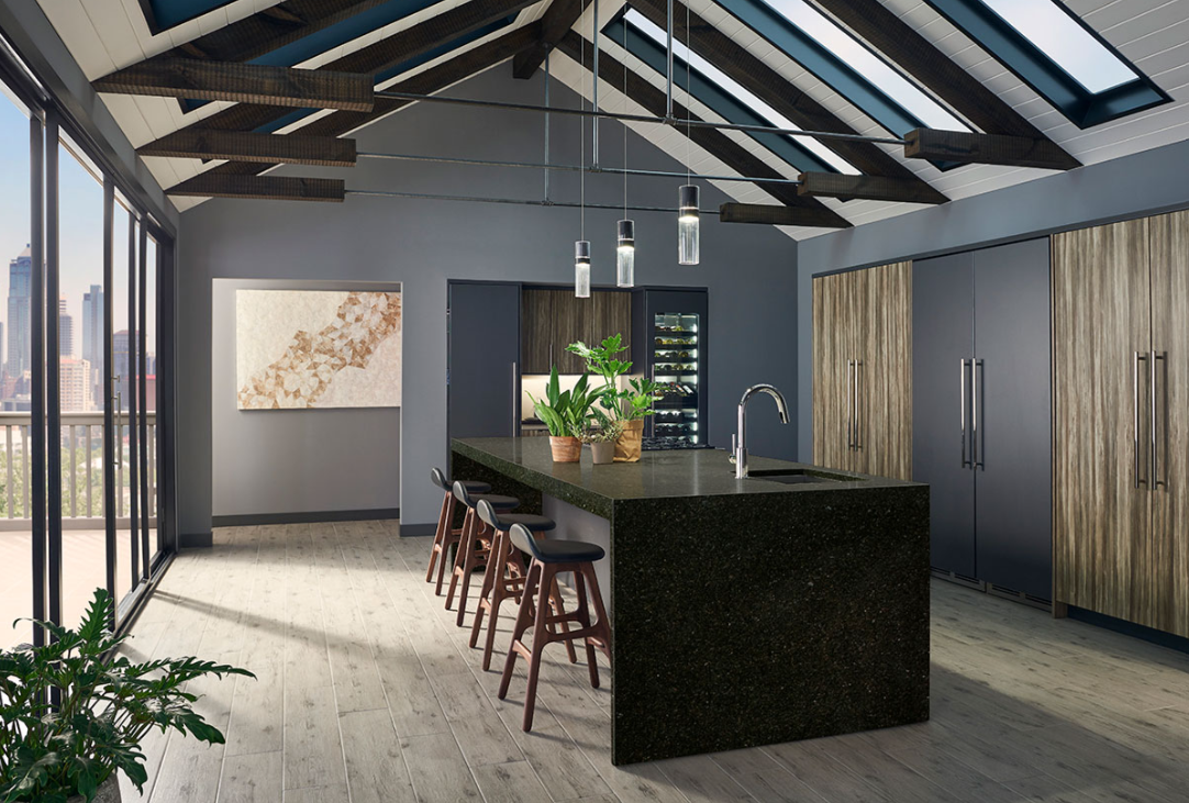 A kitchen with a large island and a lot of windows.