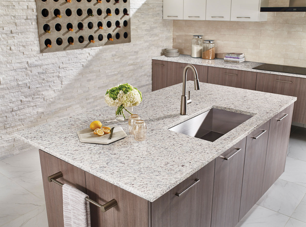 A kitchen with granite counter tops and a stainless steel sink.