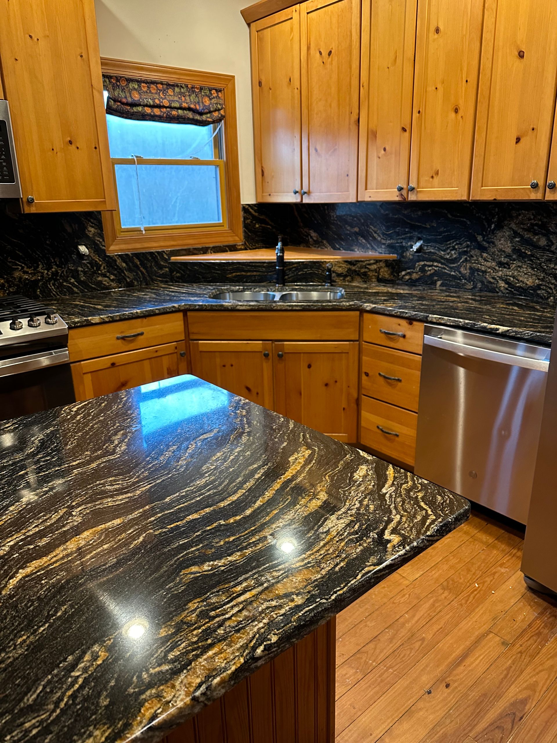 A kitchen with granite counter tops and wooden cabinets