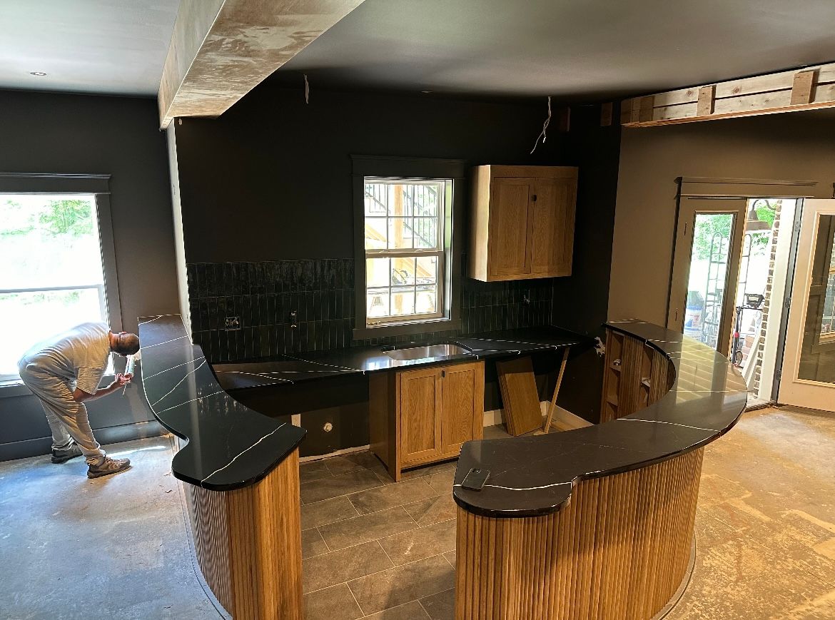 A man is working on a counter in a kitchen.