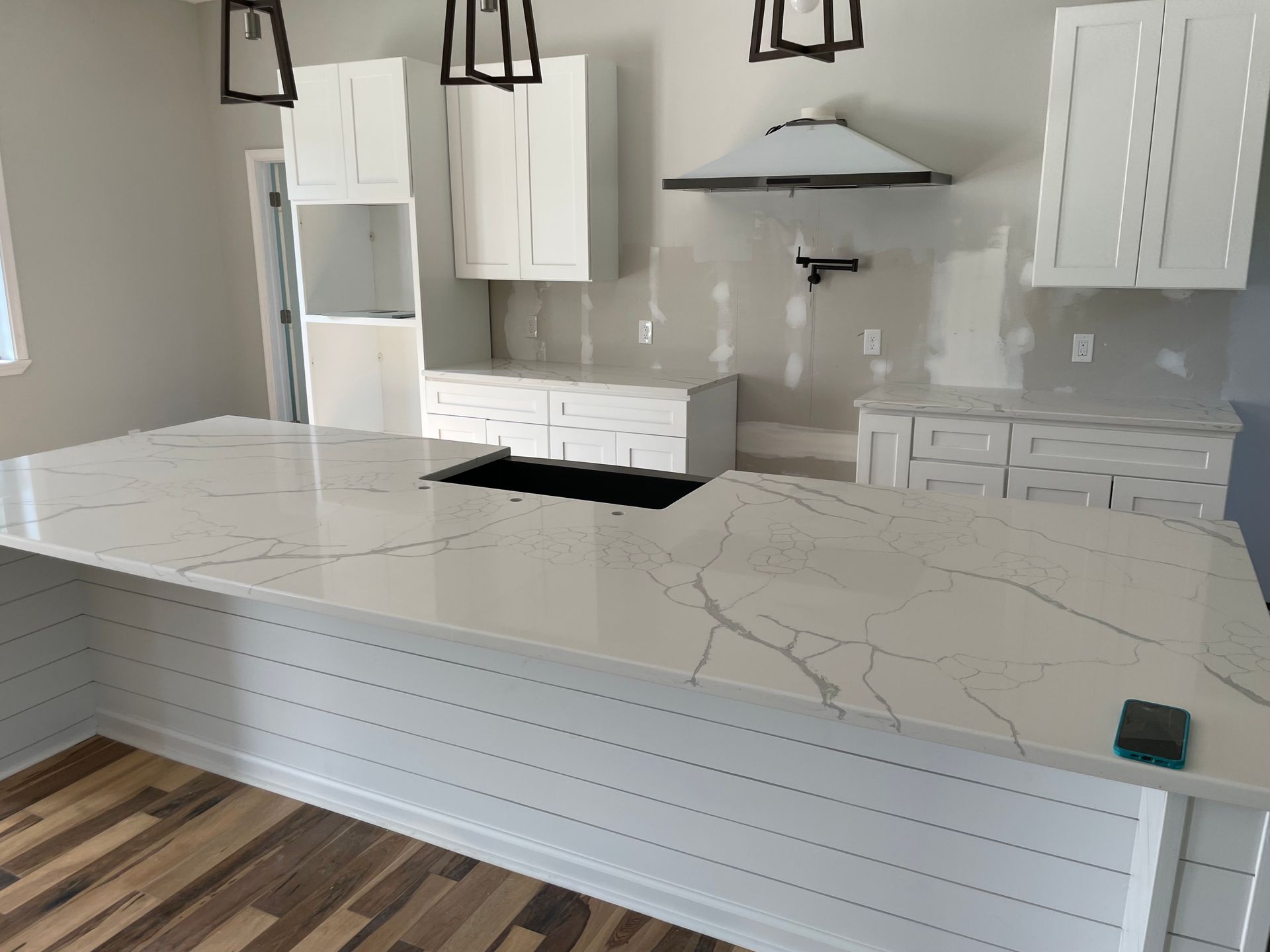 A kitchen with a large island and a sink.