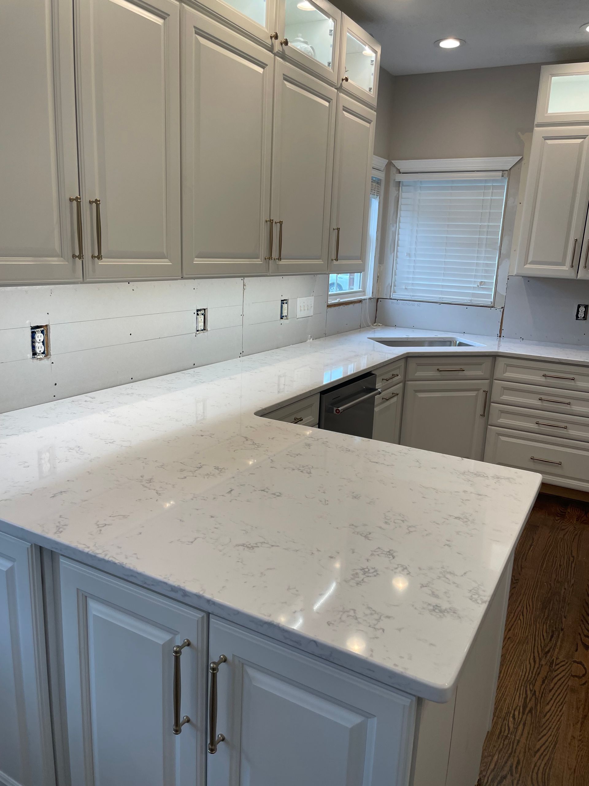 A kitchen with white cabinets and a white counter top.