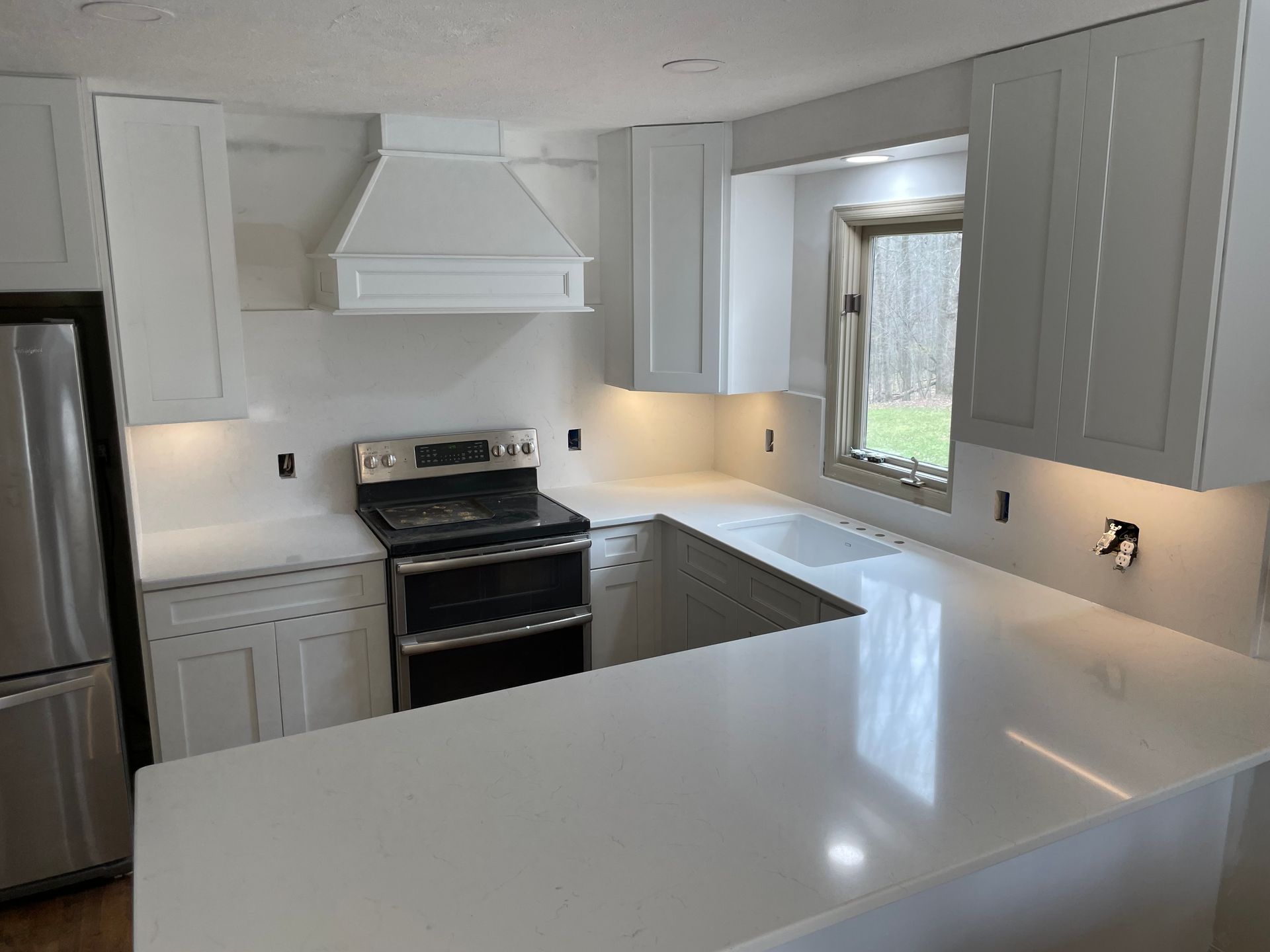 A kitchen with white cabinets and stainless steel appliances
