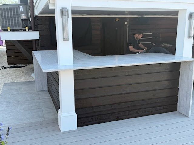 Outdoor wooden hot tub with a person inside on a deck