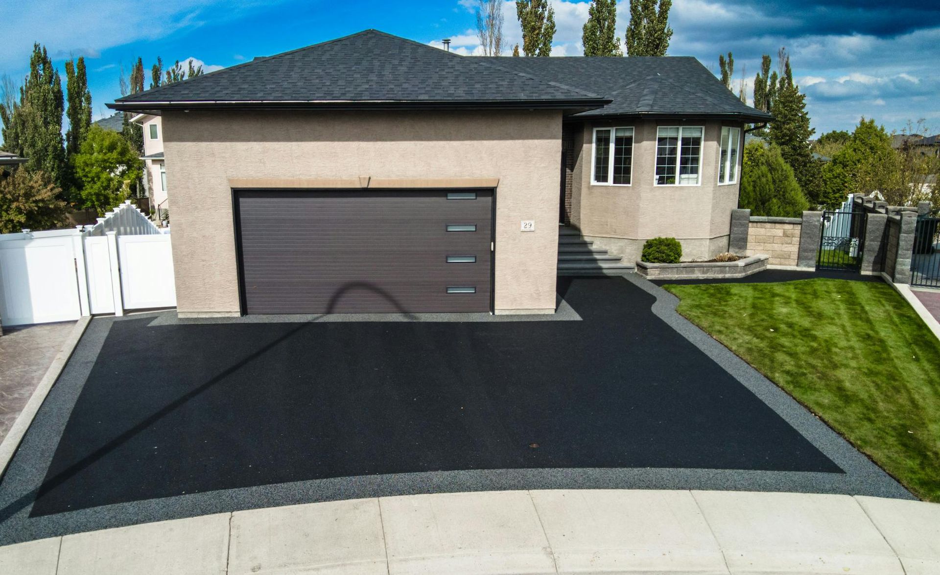A house with a black garage door and a black driveway.