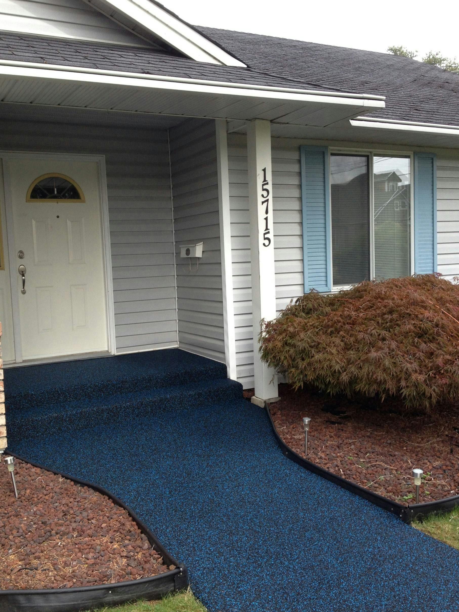 A white house with a blue walkway leading to the front door.