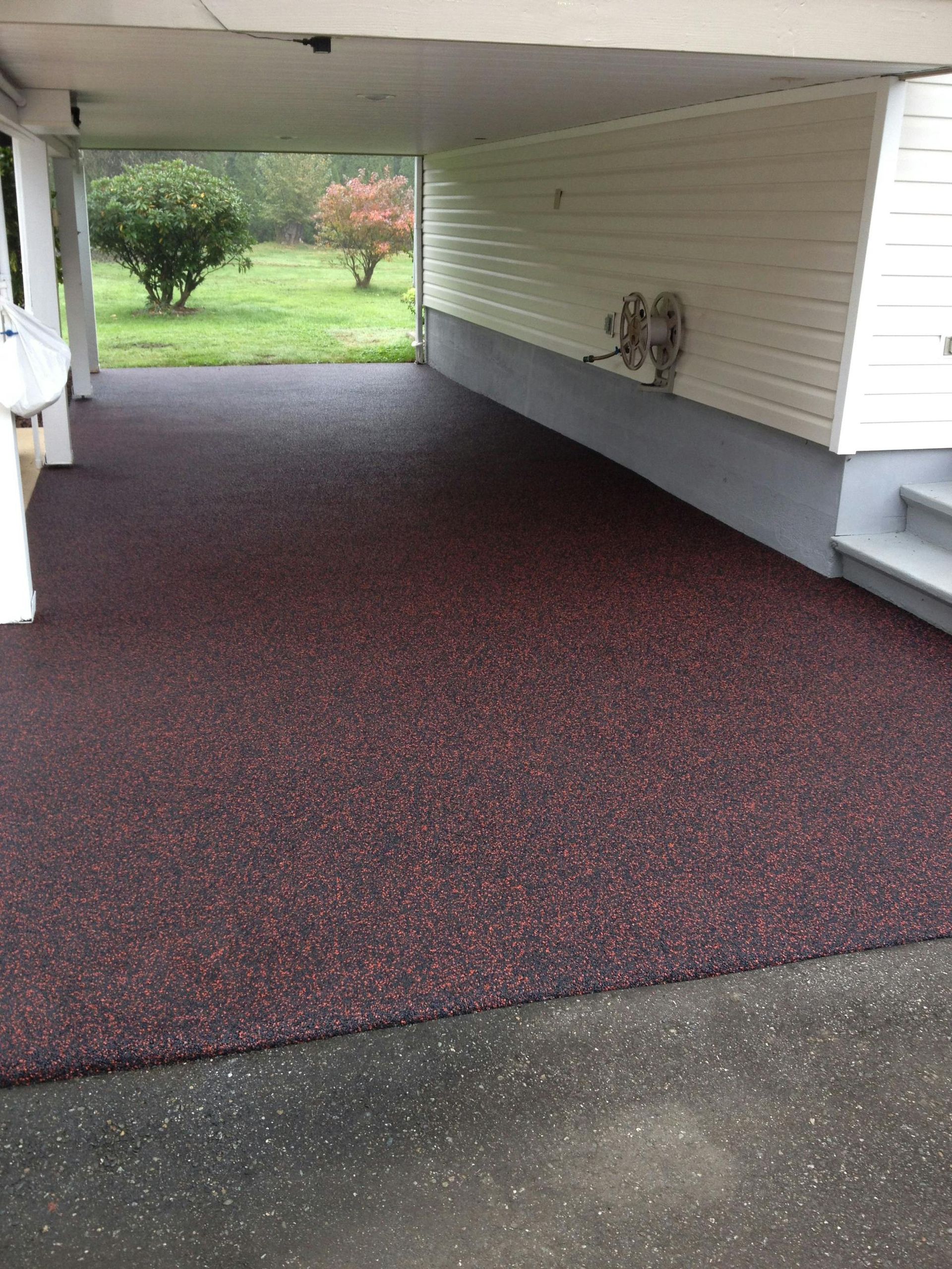 A driveway with a purple carpet and a white house in the background.