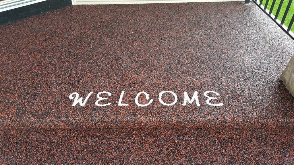 A welcome sign is painted on the floor of a building.