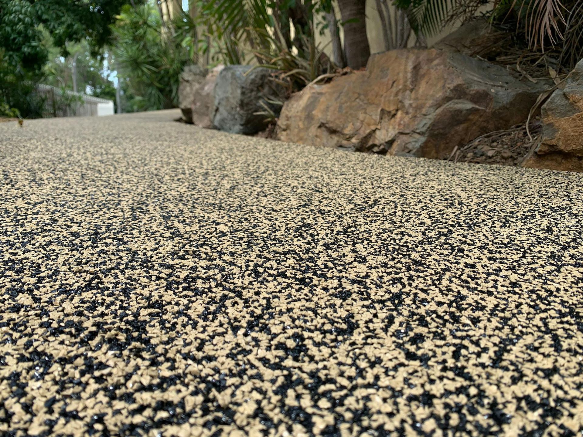 A close up of a gravel road with rocks in the background.