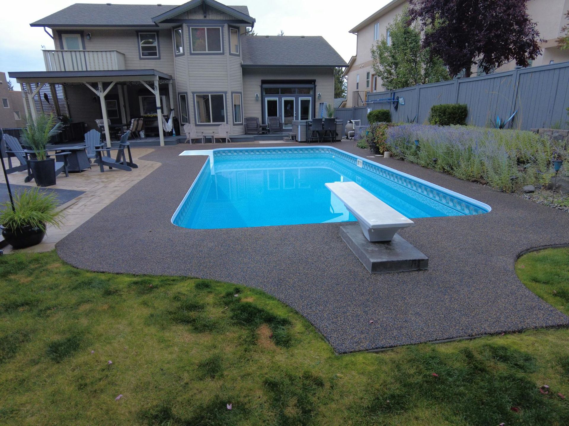 A large swimming pool in the backyard of a house.