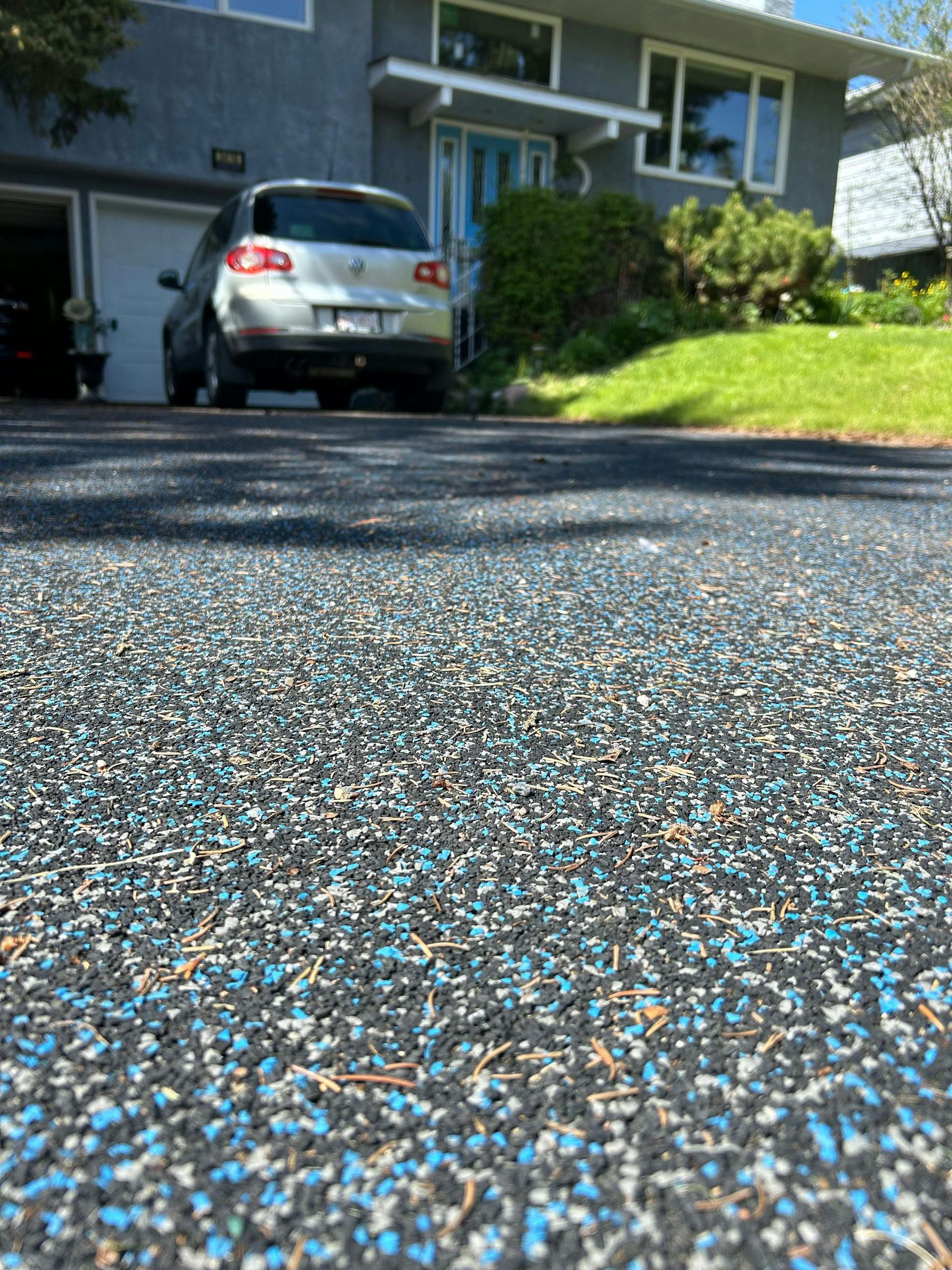 A car is parked in a driveway in front of a house.
