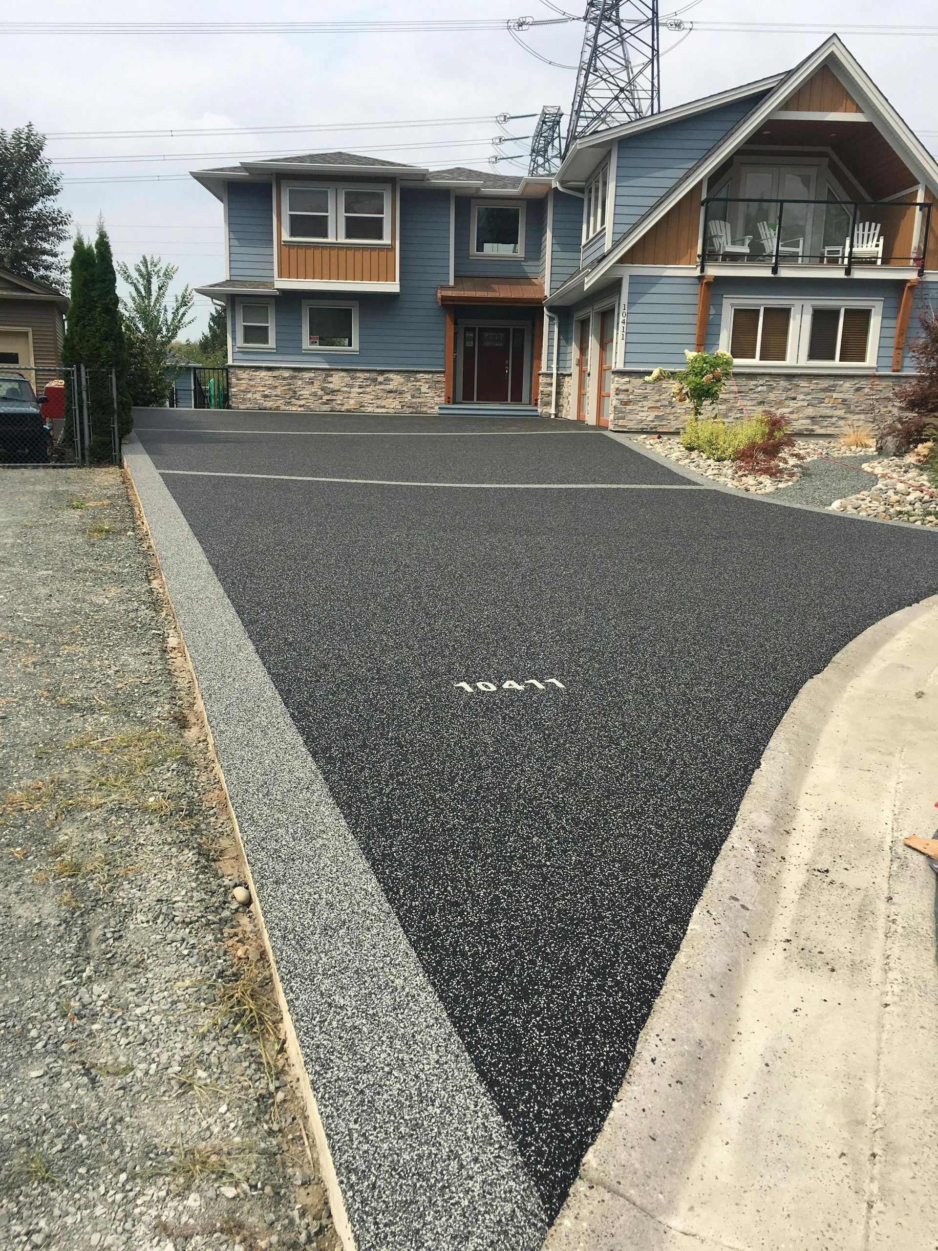 A large house with a gravel driveway in front of it.