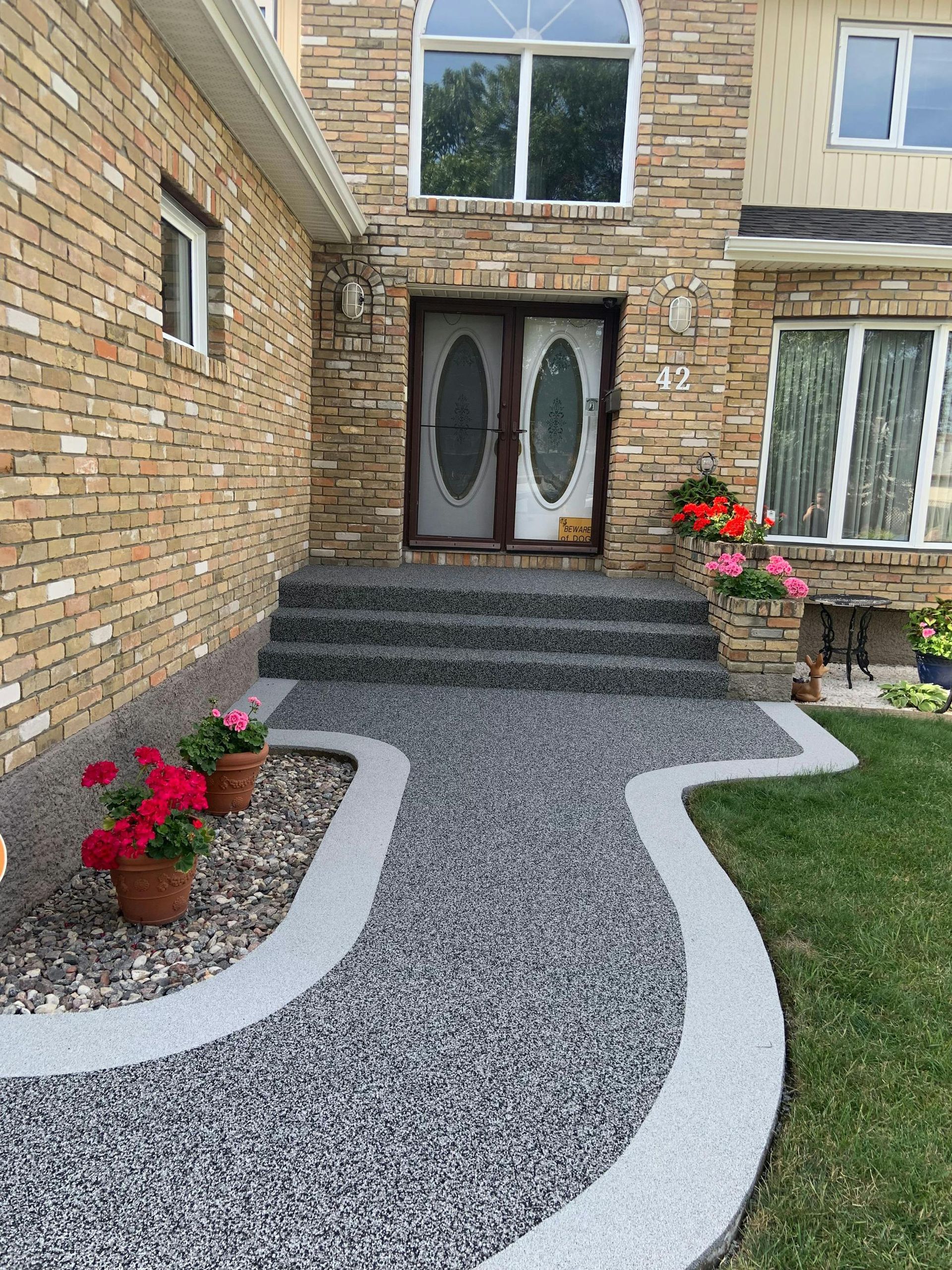 A walkway leading to the front door of a brick house.