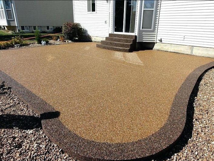 A patio with stairs and a brown border in front of a house.