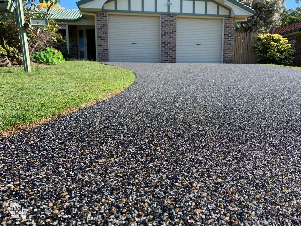 A driveway with gravel in front of a house.