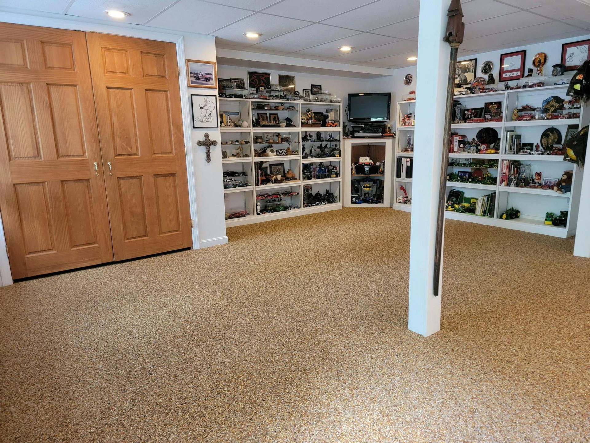 A room with a lot of shelves and a cross on the wall.