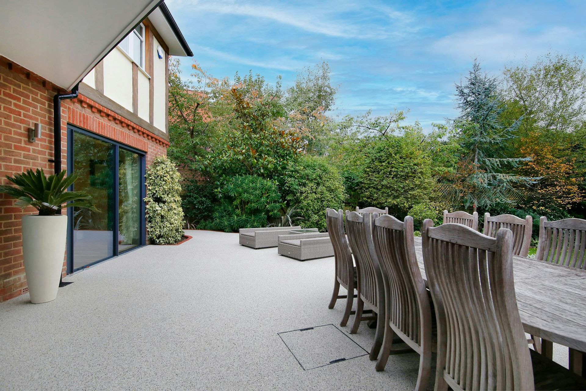 A large patio with a table and chairs in front of a house.