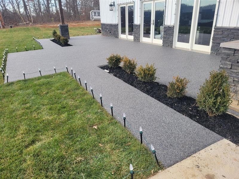A walkway leading to a house with a lot of lights on it.