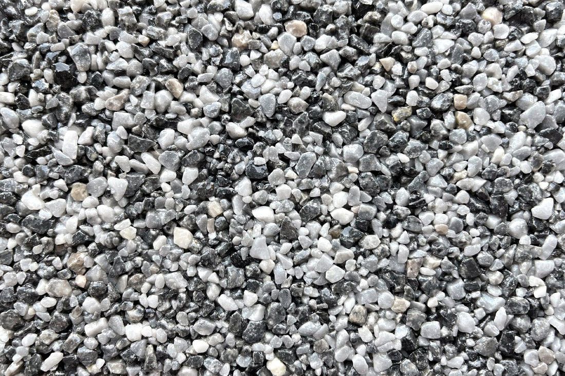 A pile of black and white gravel is sitting on the ground.