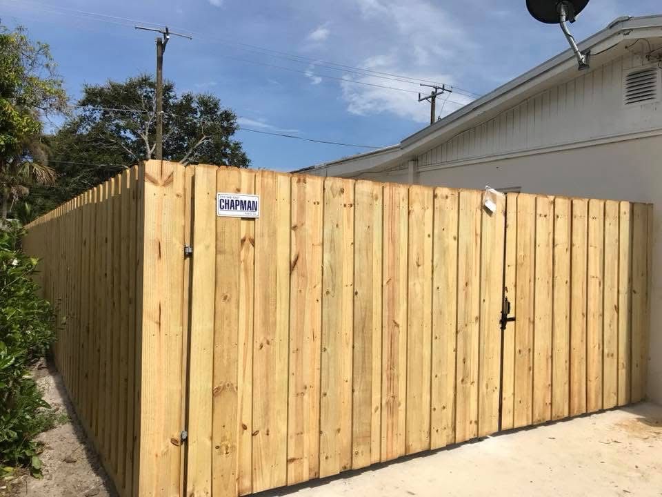 A wooden fence is sitting in front of a house.